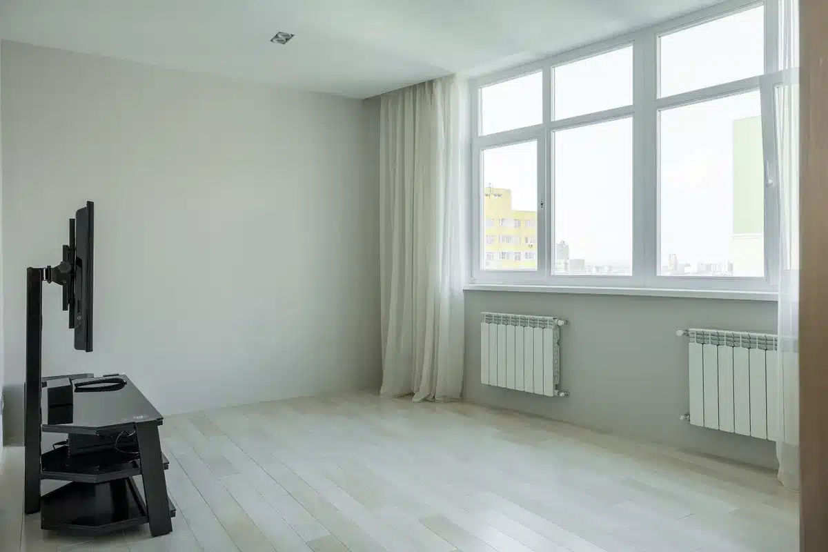 Bright modern German apartment living room with large windows and white radiators, natural daylight