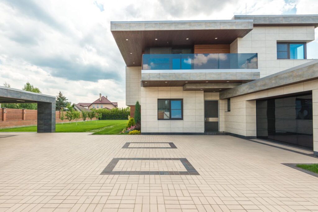 Moderne Hausfassade mit breiter gepflasterter Einfahrt