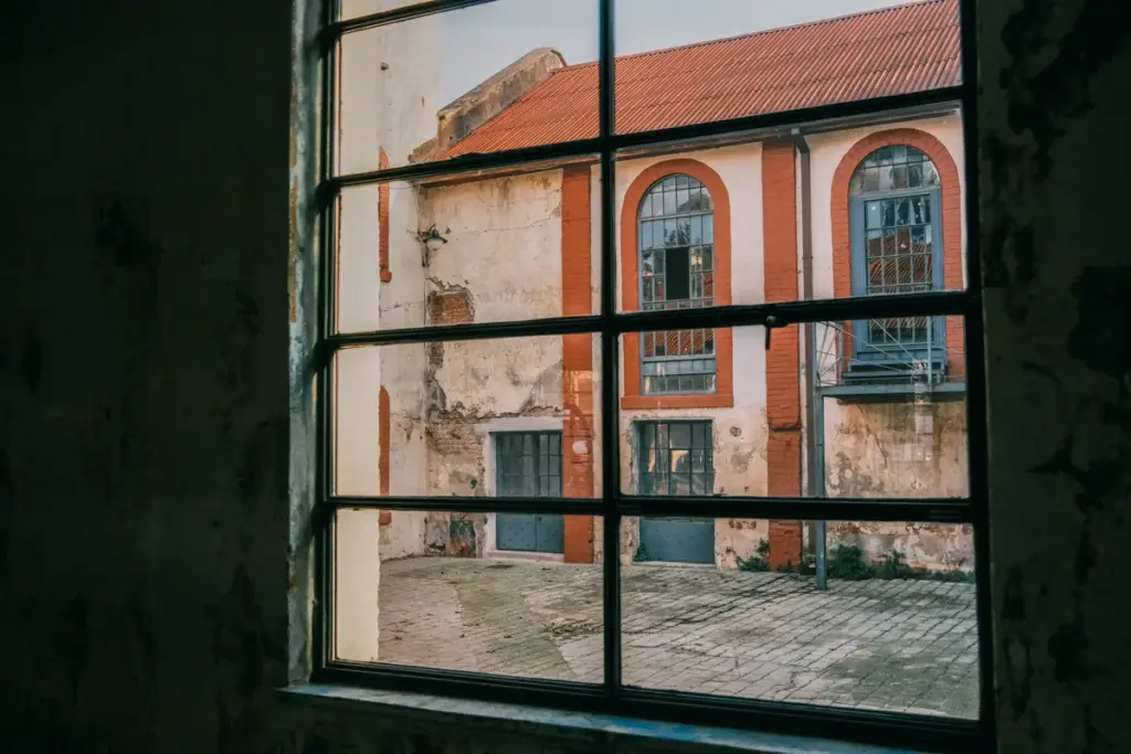 Weißes Sprossenfenster mit Blick auf typische deutsche Altbaufassade, grüner Fensterrahmen sichtbar