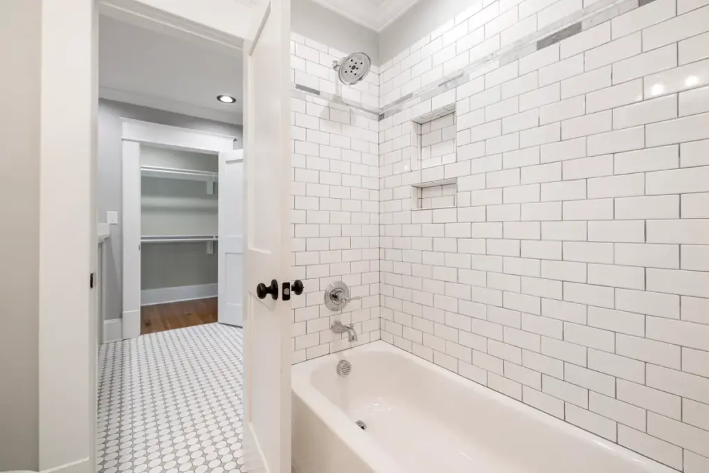 Modernes gefliestes Badezimmer mit Dusche und weißem Waschtisch in leerer Wohnung