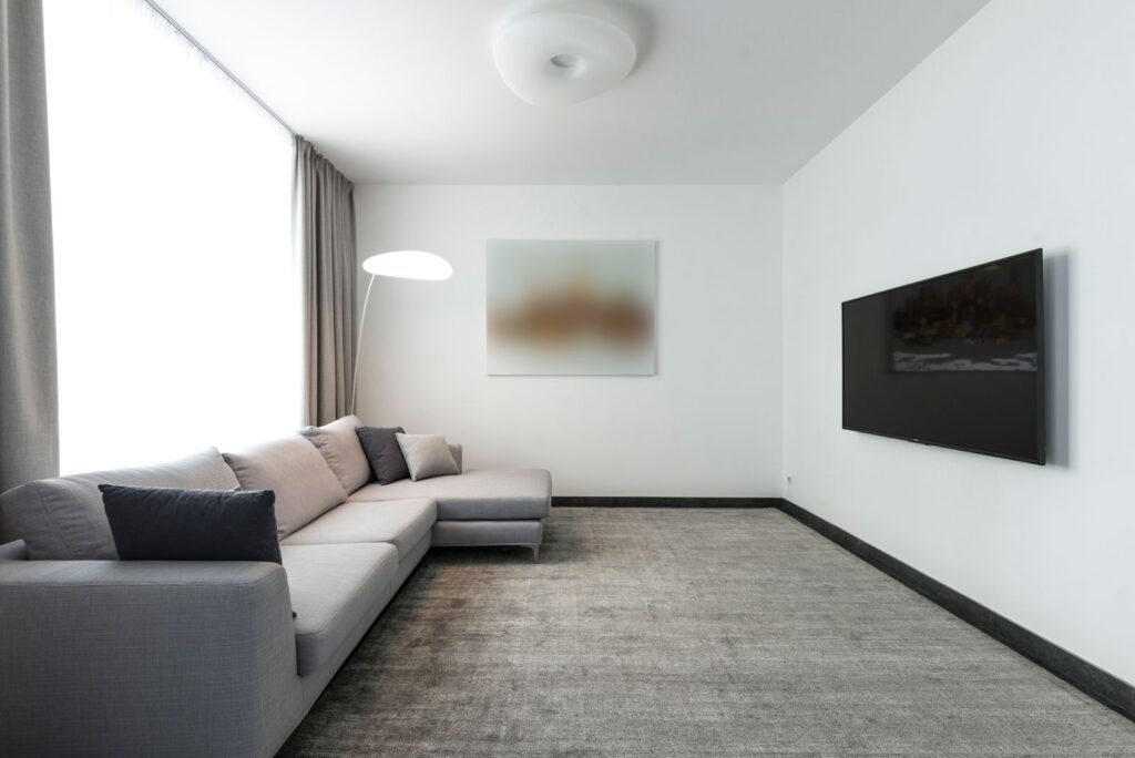 Heller, aufgeräumter Wohnraum mit Sofa und großem Fenster