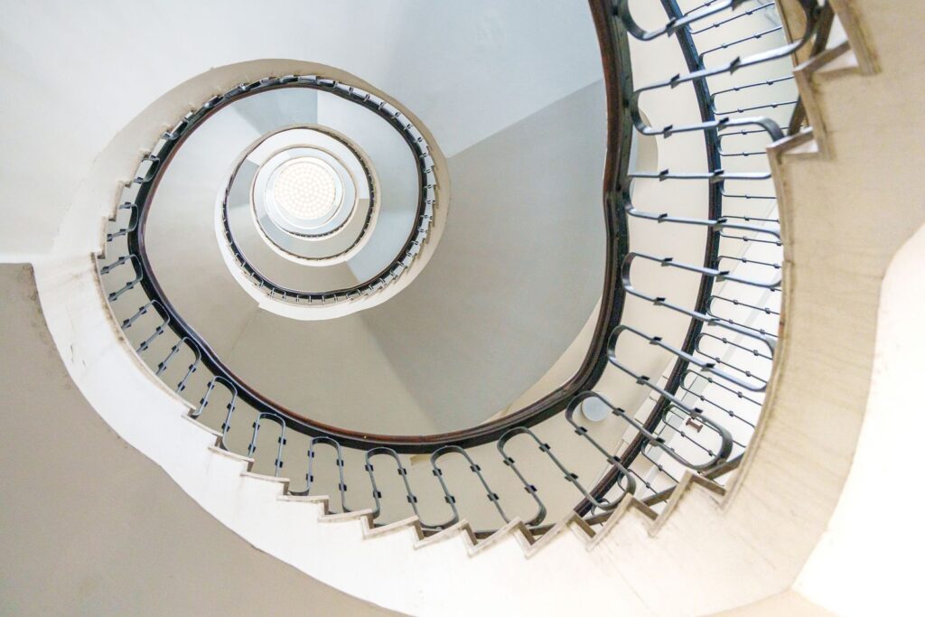 Wendeltreppe mit Handlauf und weißen Wänden
