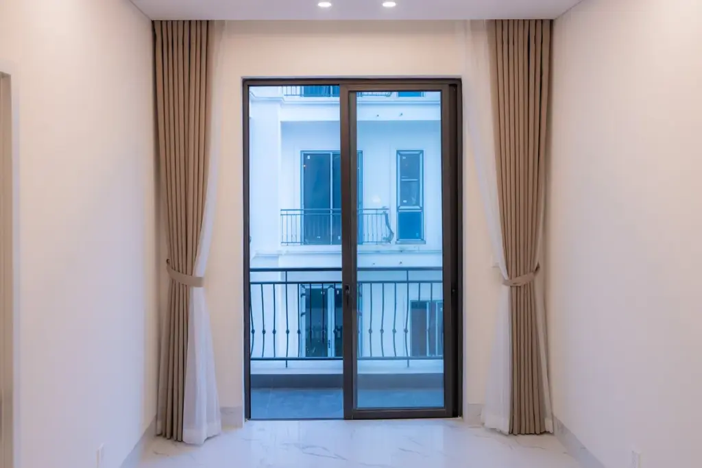 Modern living room with large balcony doors and windows overlooking urban balconies
